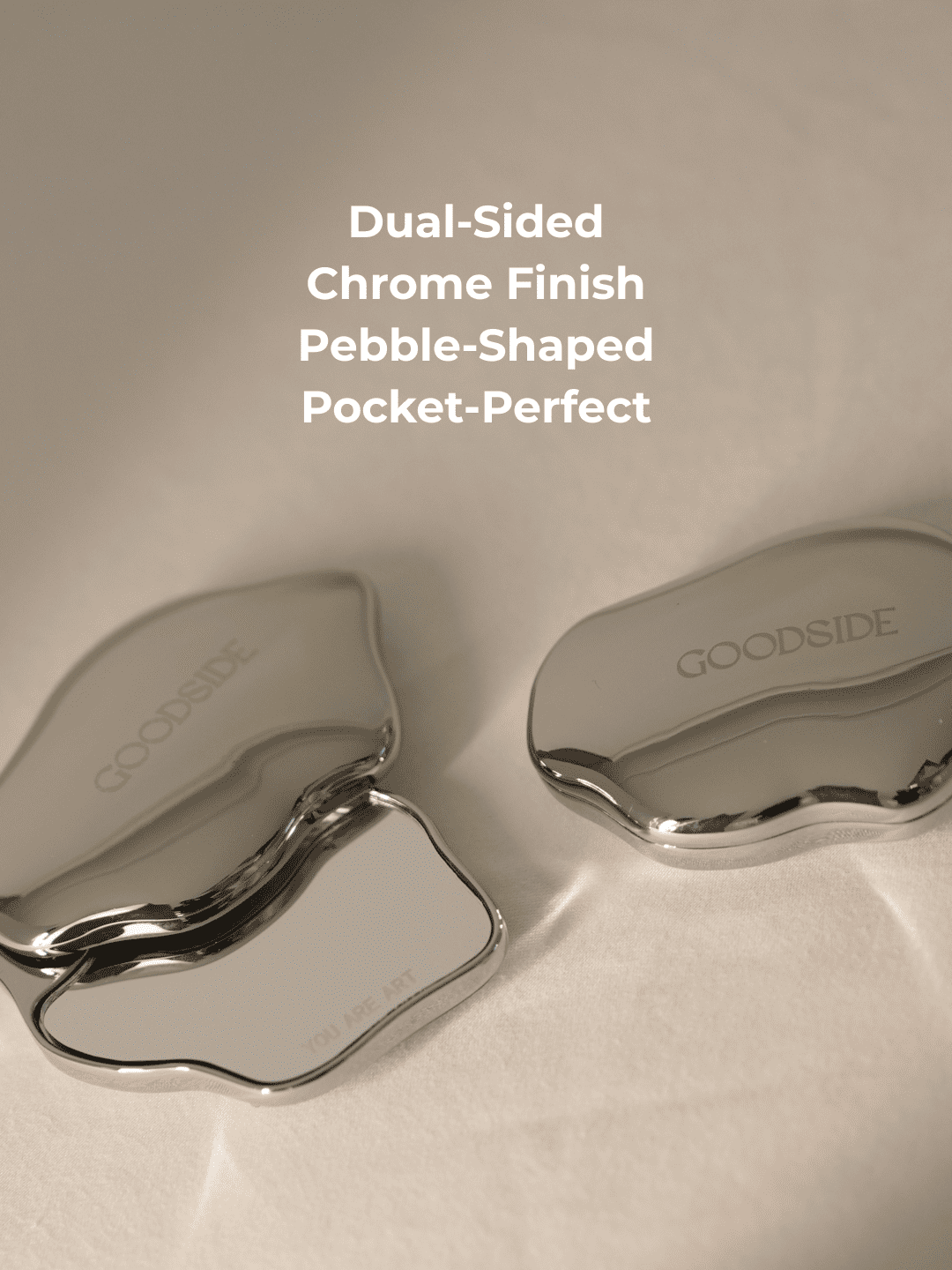 Two GOODSIDE compact mirror cases with a chrome finish and wavy pebble-shaped design, shown open and closed on a light beige background with white text overlay. - GoodSide